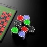 a smartphone with poker chips next to it