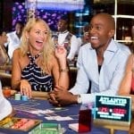 a couple of people sitting on a casino table laughing