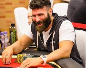 dan bilzerian playing poker on a poker table with poker chips near him